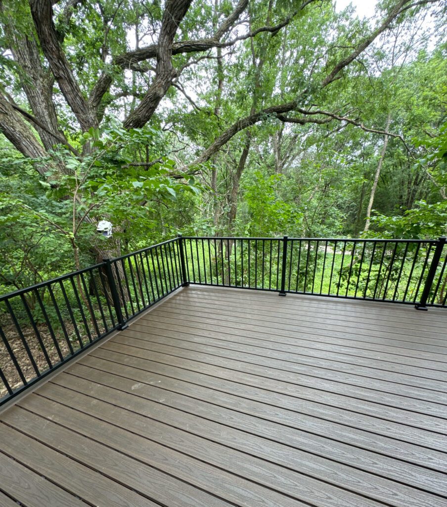 Spacious deck with black railing and trees
