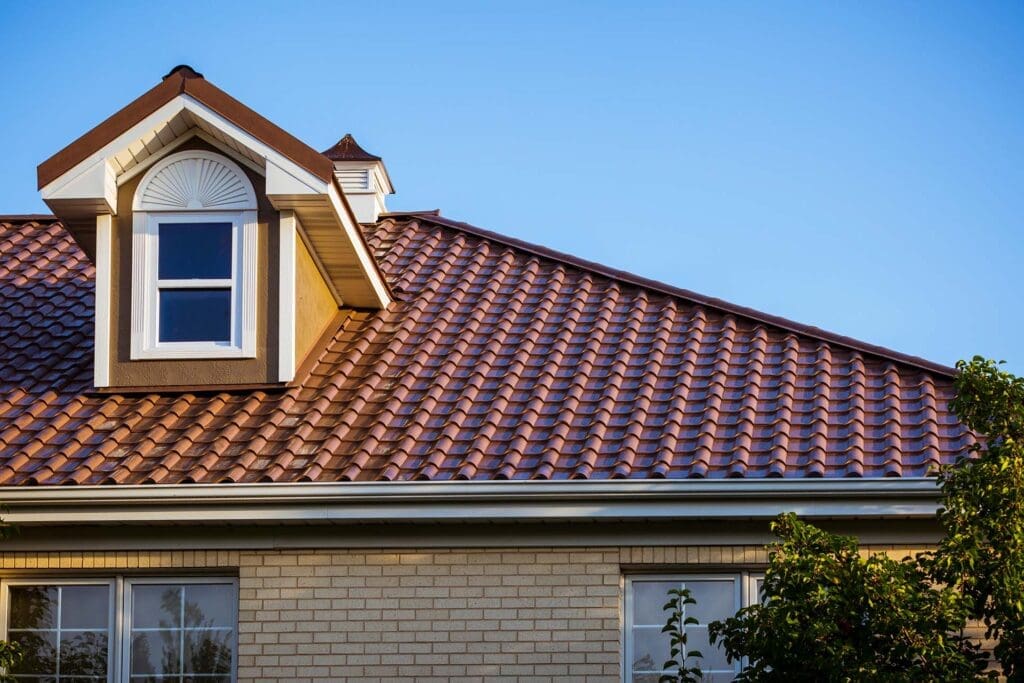 A house with a brown tiled roof under a clear blue sky.