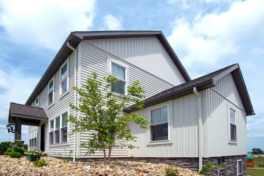 Modern house with gray siding and landscaping.