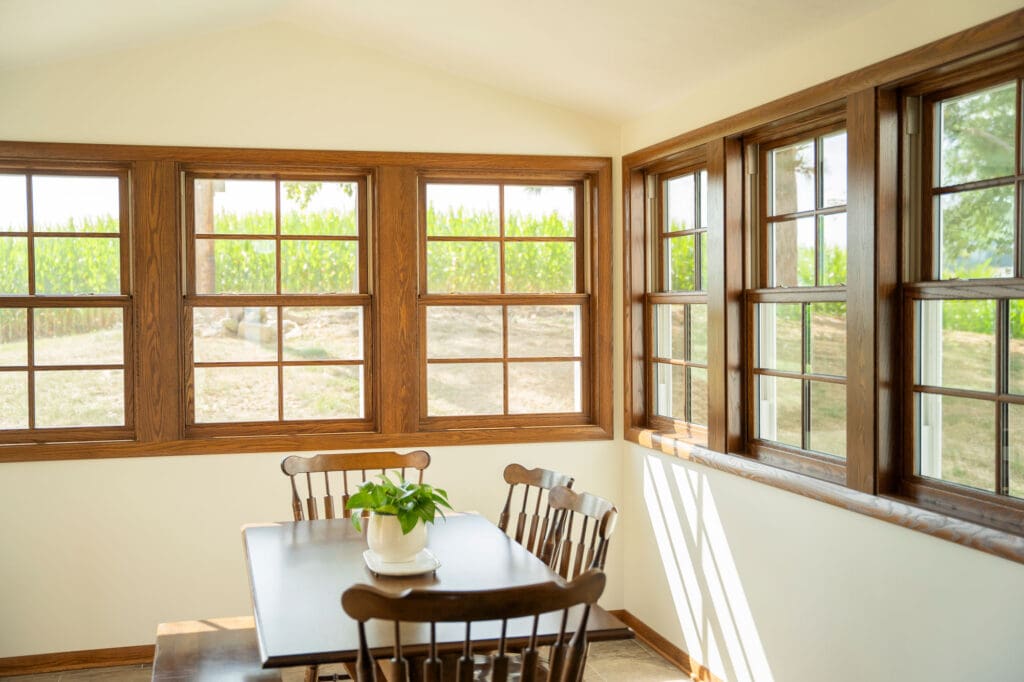 Bright dining area with large windows and wooden furniture.