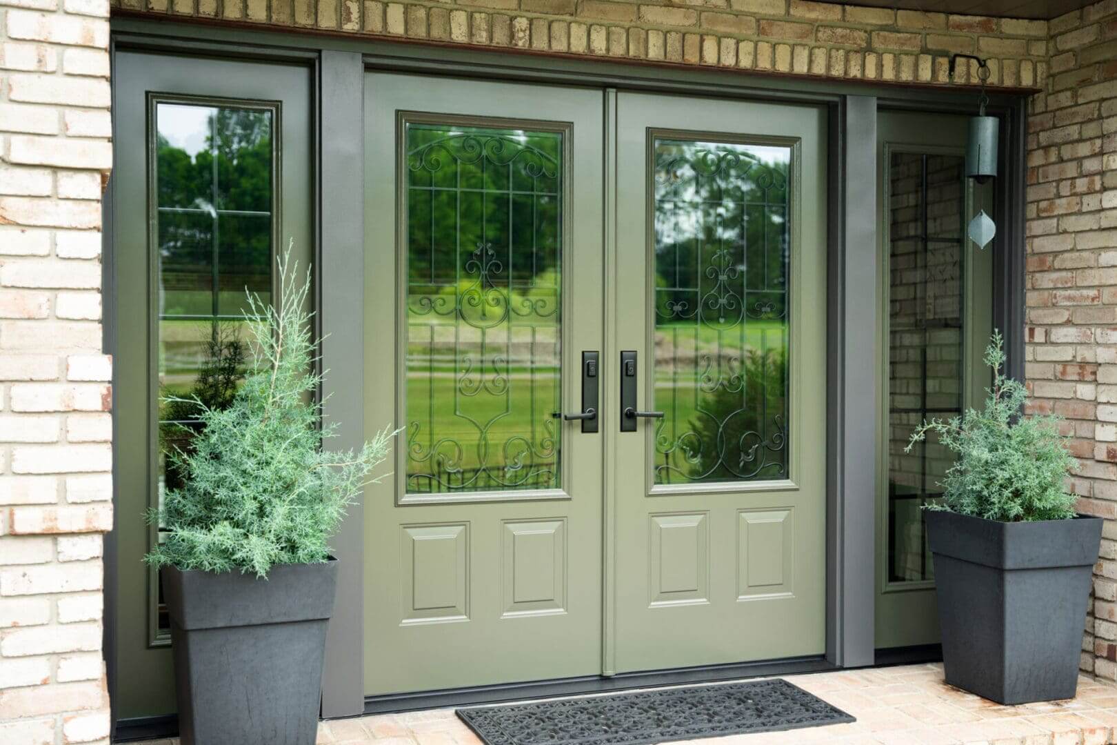 Elegant double front doors with glass panels and potted plants.