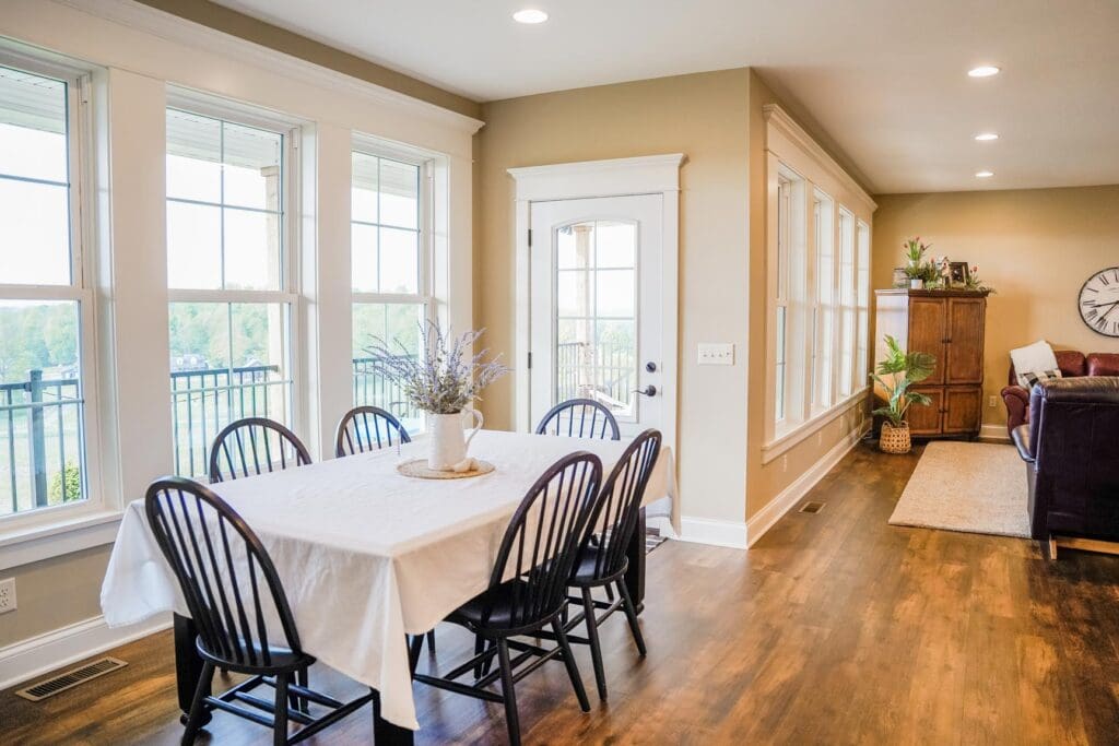 Bright dining area with wooden floors and black chairs.