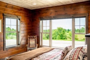 Cozy rustic bedroom overlooking green landscape