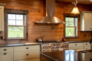 Cozy rustic kitchen with wood-paneled walls and modern stainless steel appliances.