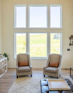 Living room with large windows and chairs.