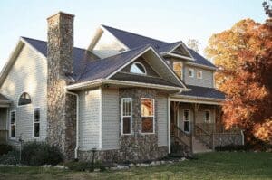 Modern house with stone chimney and porch.
