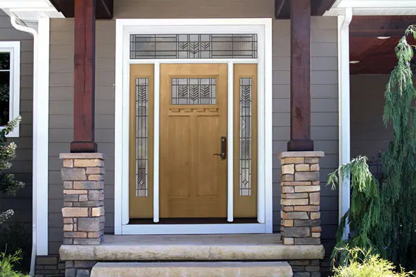 A front gate of a house with concrete stairs.