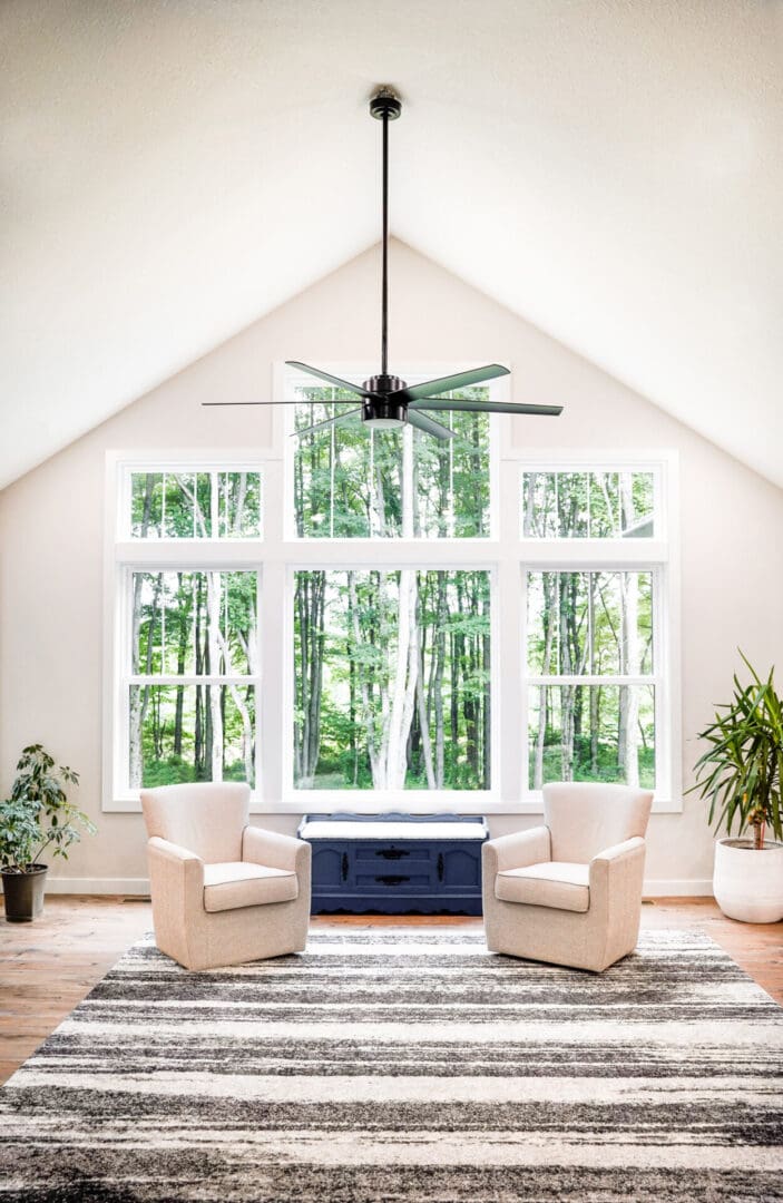 Bright living room with large windows and cozy chairs.