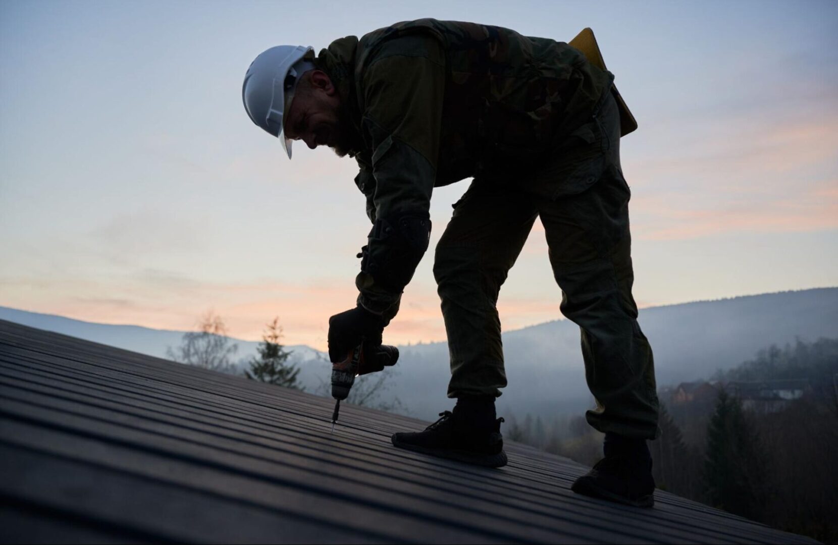 Worker in a hard hat installing a roof. 