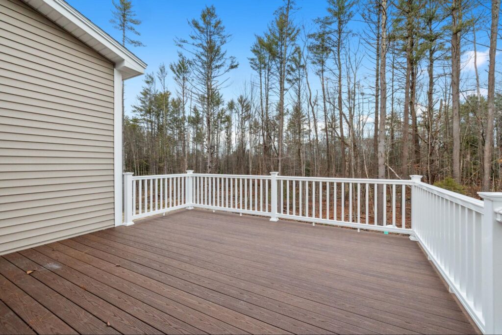 Deck railing with a forest in the background.