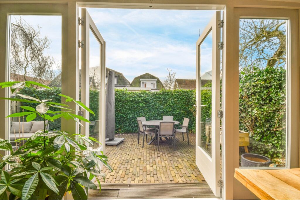 Glass patio doors opening up to a seating area outdoors.