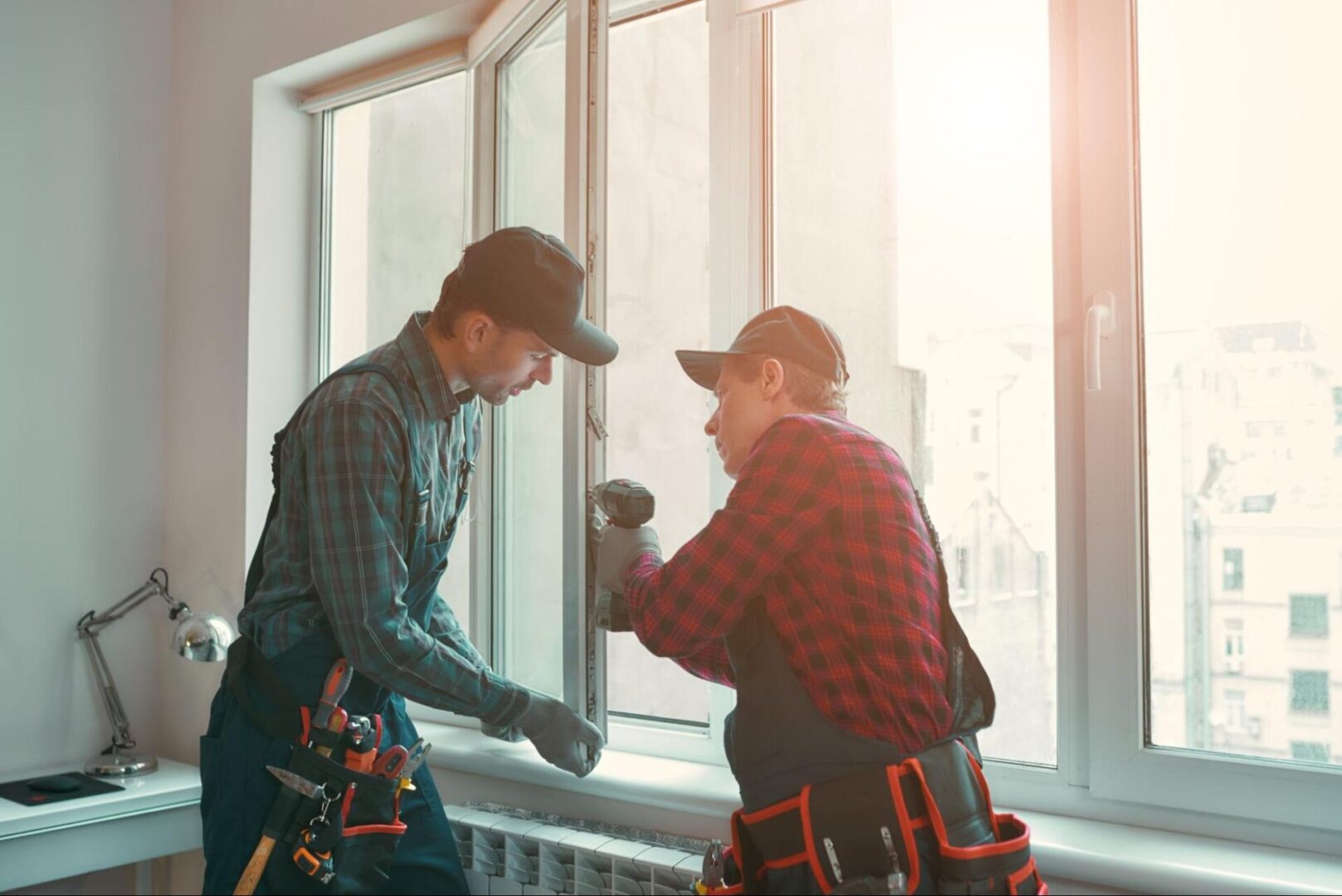 Two male workers installing a new window. 