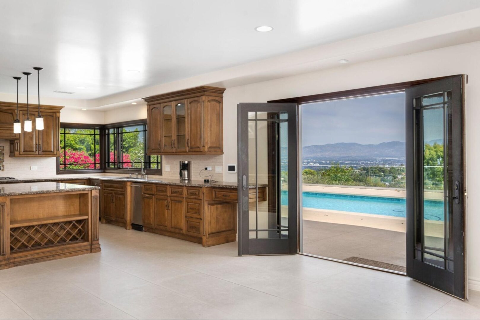 Kitchen with glass doors overlooking a pool. 