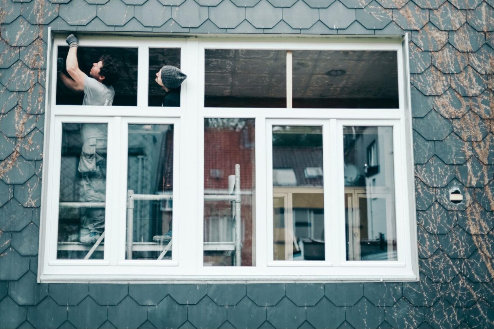 Two men showcasing the process of replacing windows for enhanced functionality and style.