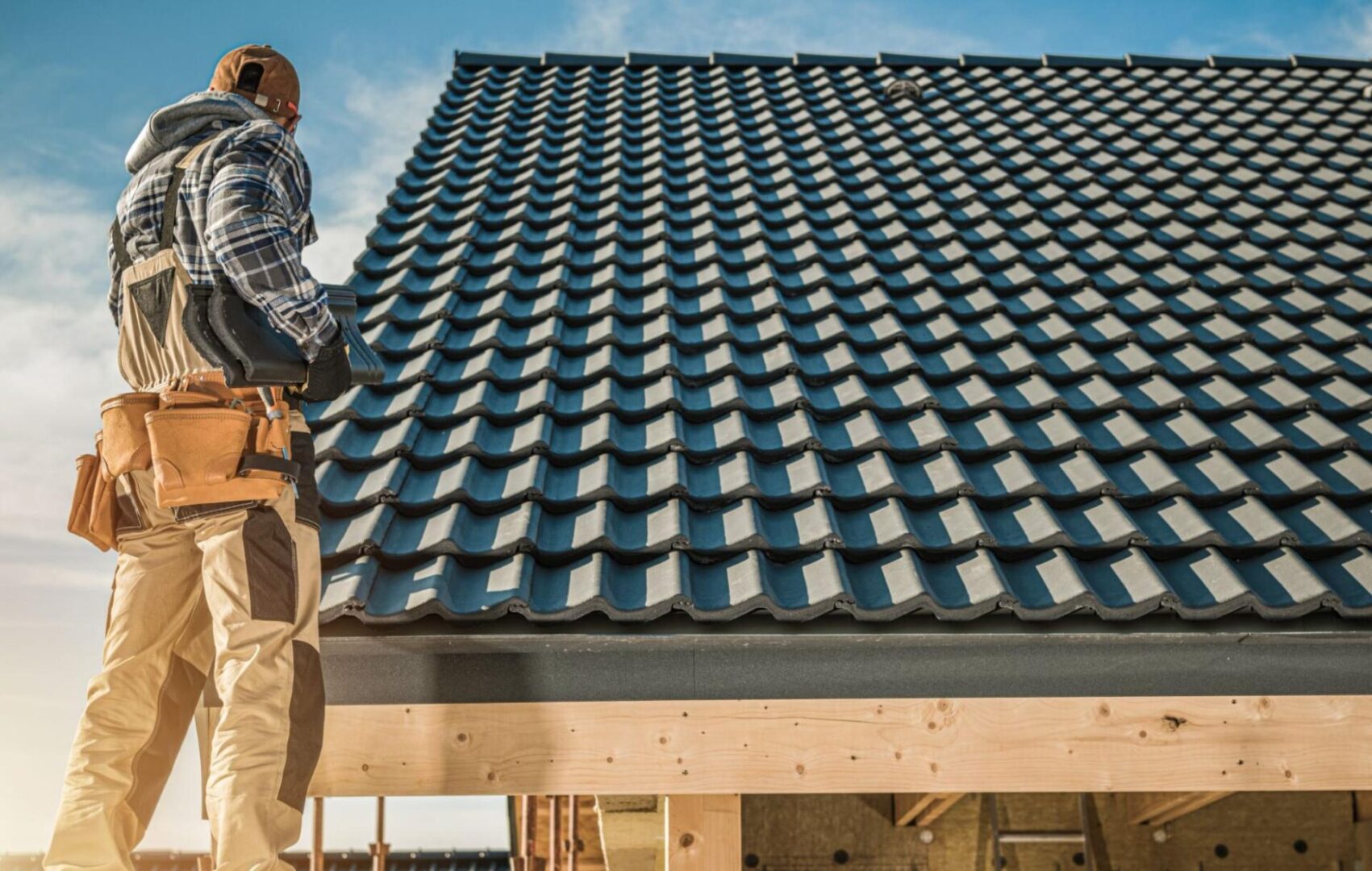 A roofer checks for damage to the tile roofing. 