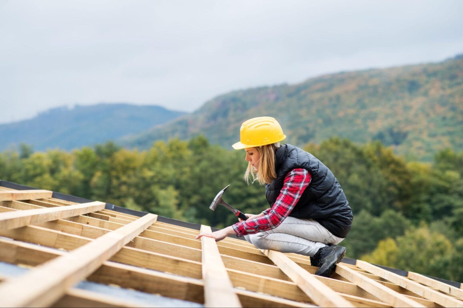 A female roofing contractor is fixing a roof.